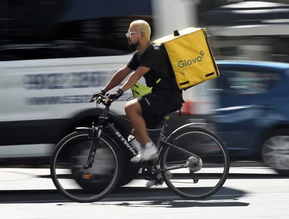 Archivo - Un rider de la empresa de reparto de comida a domicilio Glovo, pasea por una calle de Madrid con su bicicleta.