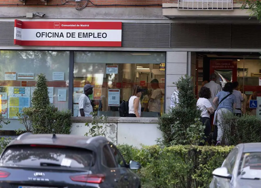 Archivo - Varias personas hacen cola en una oficina del SEPE en Madrid.
