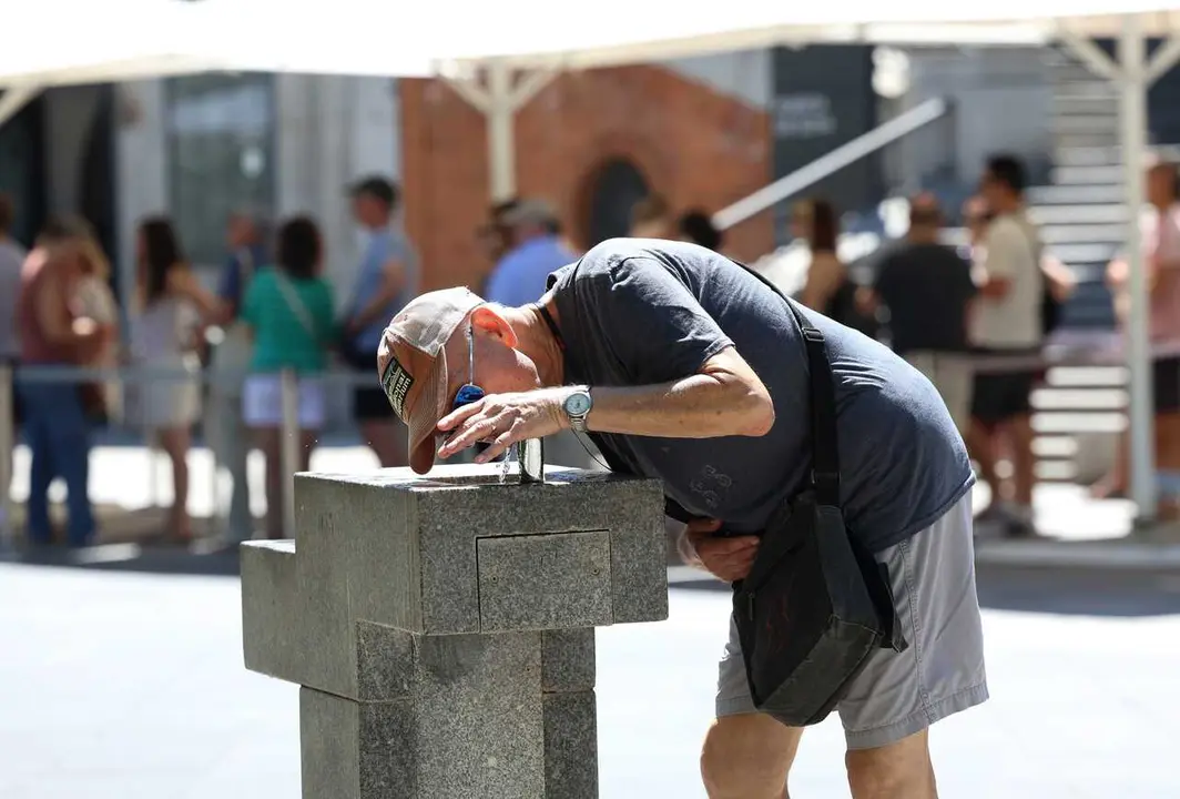 Archivo - Un hombre bebe agua de una fuente durante una segunda ola de calor, a 23 de julio de 2024, en Madrid (Espa&ntilde;a).