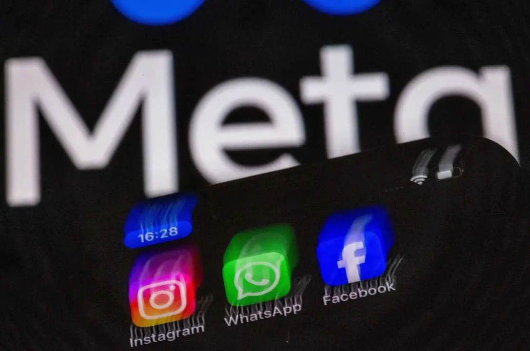 Archivo - Fotograf&iacute;a de archivo de los logos de Instagram, Facebook y WhatsApp en un tel&eacute;fono m&oacute;vil, con el logo de Meta de fondo