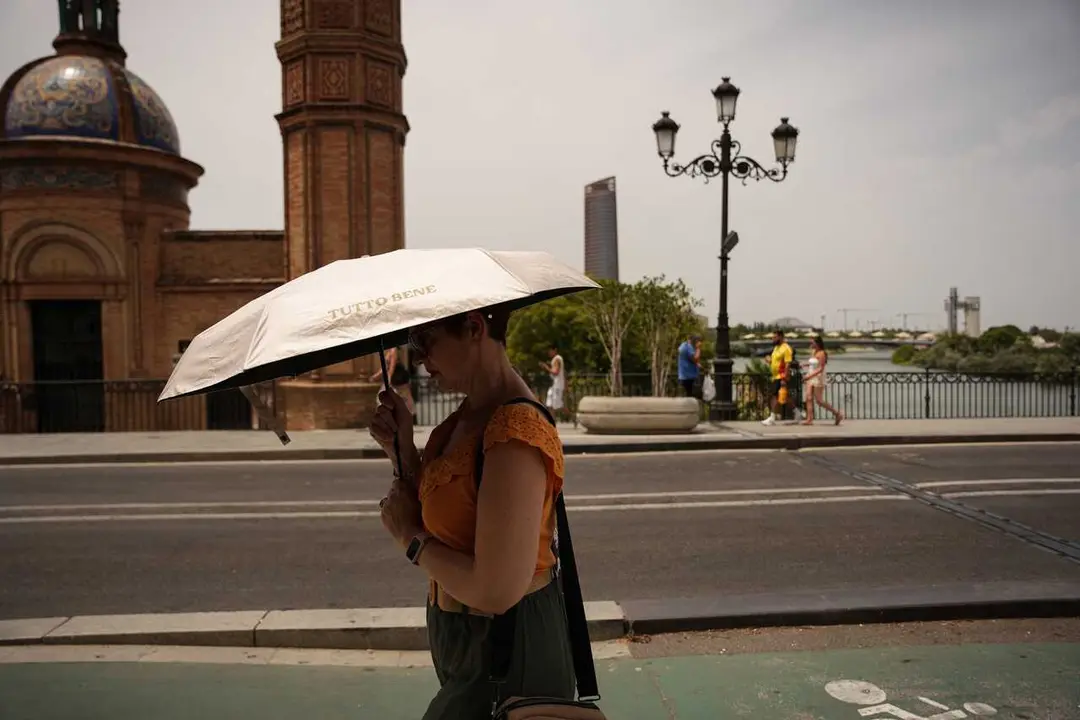 Una mujer se protege del sol con una sombrilla. A 23 de junio de 2026, en Sevilla (Andaluc&iacute;a, Espa&ntilde;a). 