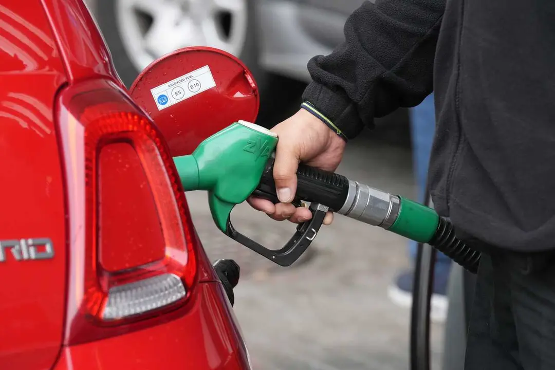 Archivo - Una persona echa combustible