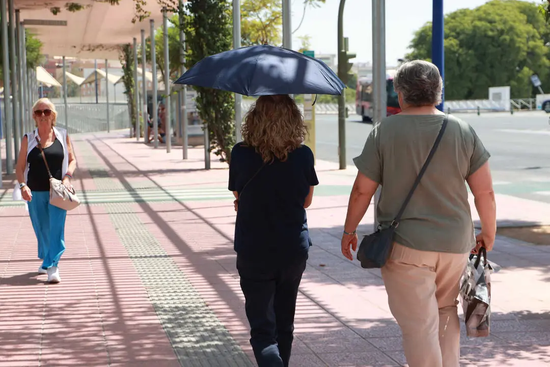 Archivo - Una mujer usa un paraguas para protegerse de las altas temperaturas, a 24 de agosto en Sevilla (Andaluc&iacute;a, Espa&ntilde;a). La ola de calor acaba este jueves con la llegada de una vaguada que bajar&aacute; las temperaturas. El fin de semana se esperan lluvias 