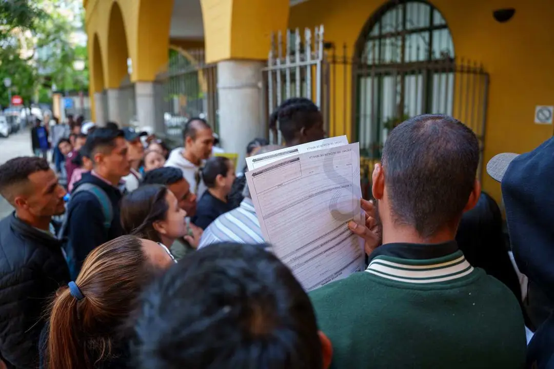 Archivo - Personas migrantes hacen cola para la tramitaci&oacute;n de su regularizaci&oacute;n administrativa en Sevilla.
