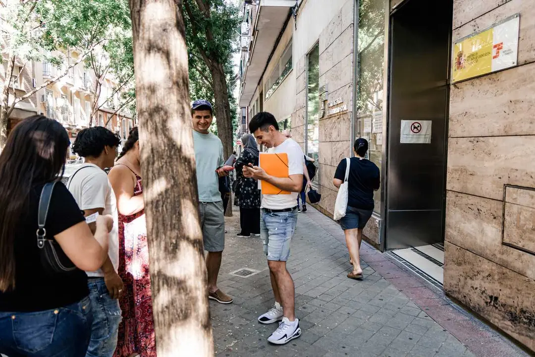 Varias personas migrantes esperan en el exterior de una oficina de la Seguridad Social, a 30 de junio de 2026, en Madrid (Espa&ntilde;a), para acogerse al proceso de regularizaci&oacute;n