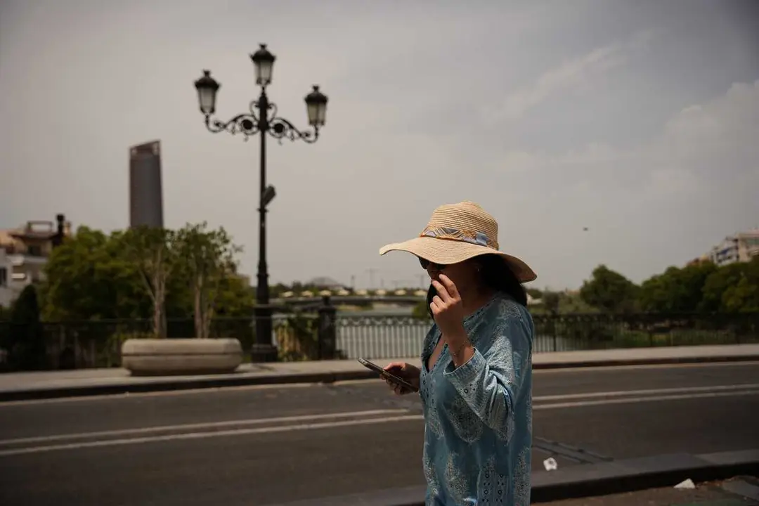 Una mujer se protege del sol con un sombrero. A 23 de junio de 2026, en Sevilla (Andaluc&iacute;a, Espa&ntilde;a).