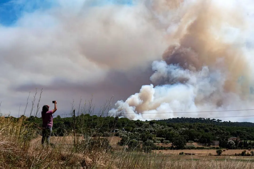 Una persona le hace una foto al humo del incendio, en La Bisbal d'Empord&agrave;, Girona, Catalunya (Espa&ntilde;a)