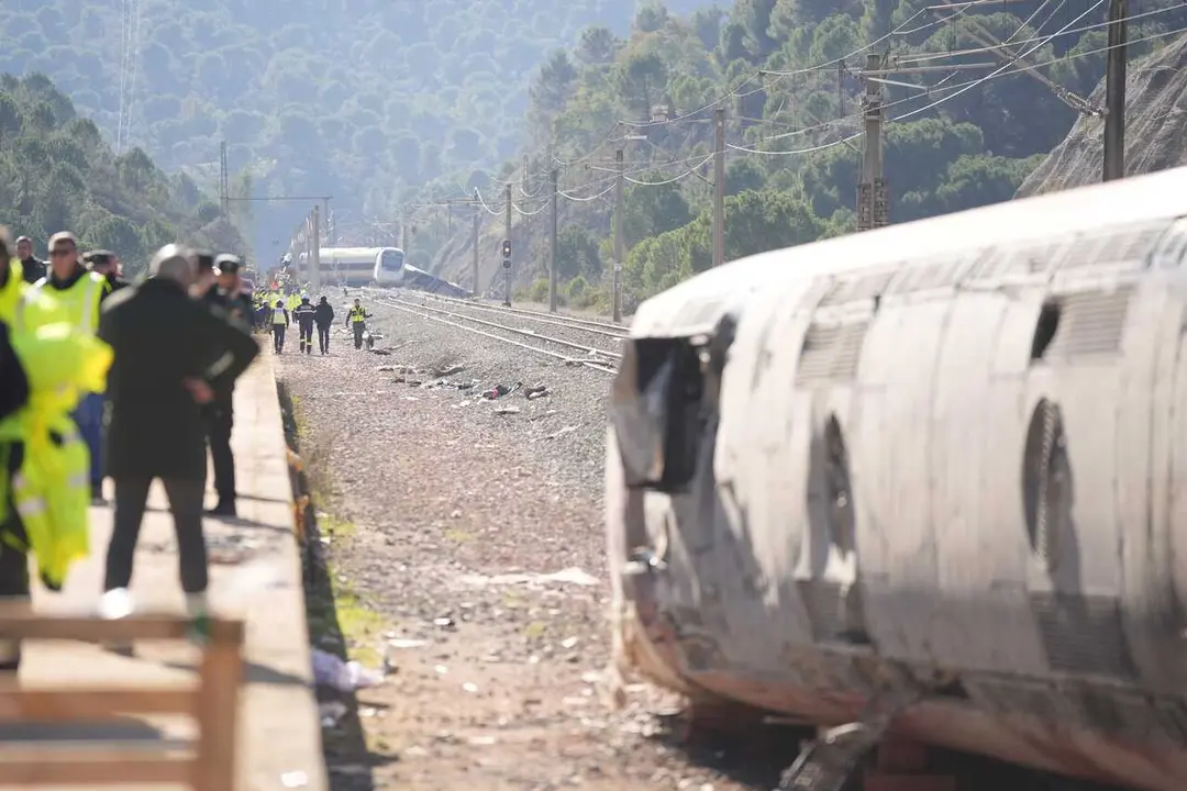 Archivo - Uno de los vagones del tren de Iryo con el Alvia accidentado al fondo.
