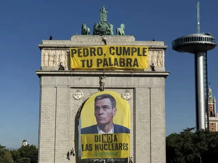 Activistas despliegan una pancarta en el arco de Moncloa