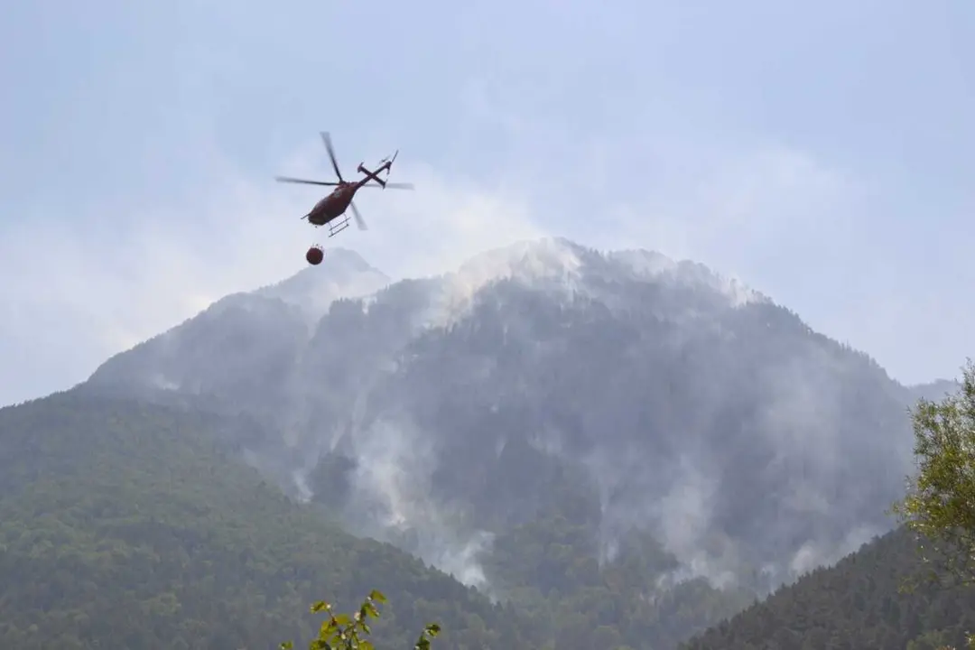 Uno de los helic&oacute;pteros que trabajan en el incendio de Plan (Huesca) cargando agua del ib&oacute;n
