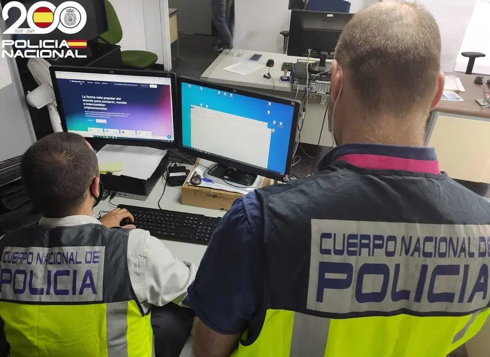 Dos agentes del  Grupo de Delincuencia Econ&oacute;mica y Delitos Tecnol&oacute;gicos de la Jefatura Superior de Polic&iacute;a de Baleares, de espaldas.