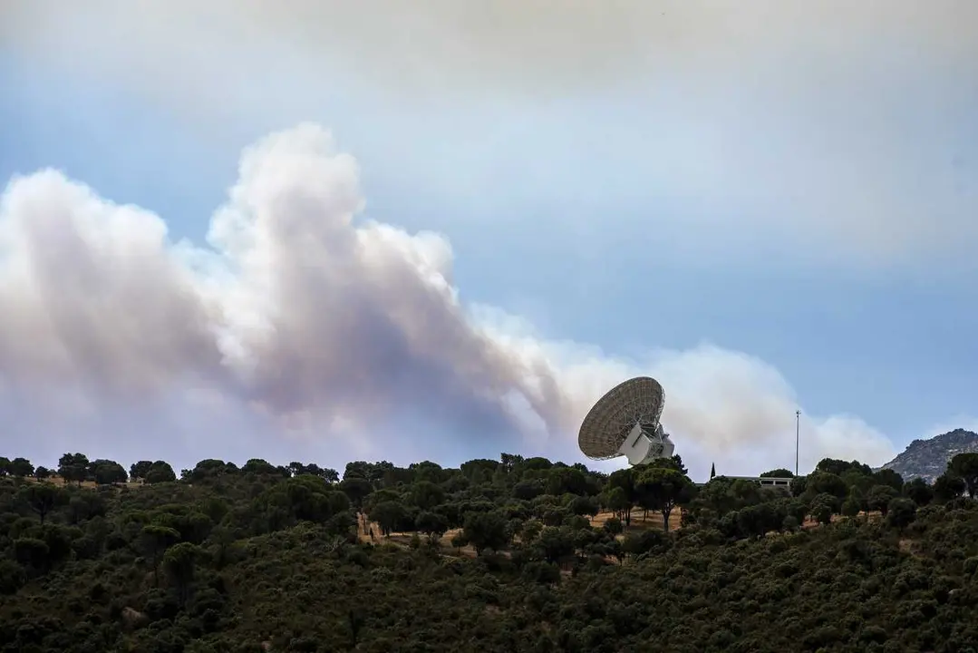 El humo de un fuego cercano sobrevuela una antena de la NASA, a 24 de julio de 2026, en Robledo de Chavela, Madrid (Espa&ntilde;a). Los incendios que afectan a la Comunidad de Madrid siguen avanzando sin control y se han unido en un solo foco, mientras que en &Aacute;v