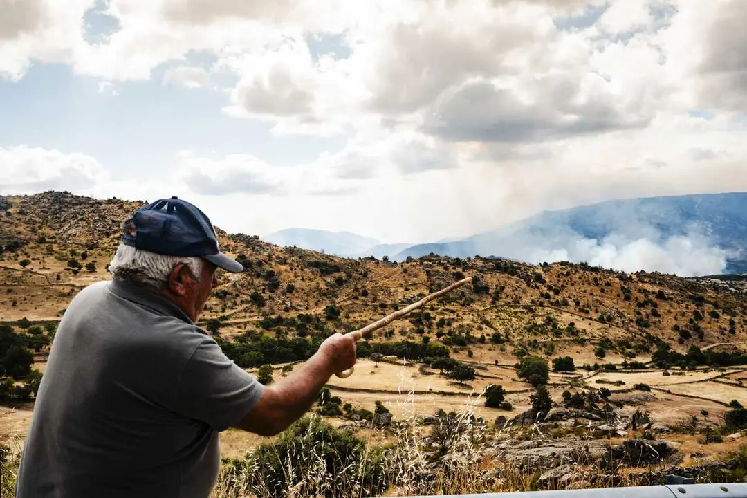 Yna persona se&ntilde;ala una columna de humo del fuego forestal, a 25 de julio de 2026, en Navaluenga, &Aacute;vila, Castilla y Le&oacute;n (Espa&ntilde;a). El incendio forestal de Burgohondo (&Aacute;vila)