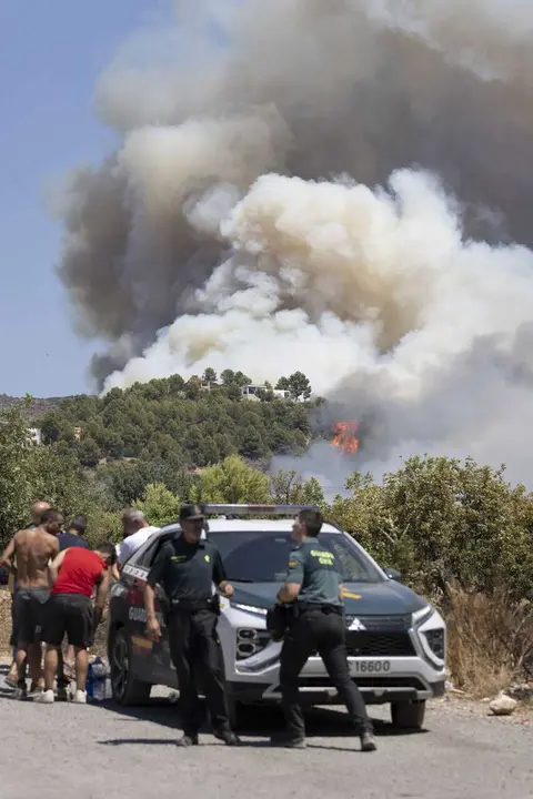Varias personas y guardia civil durante las labores de extinci&oacute;n de un incendio forestal en Vall d'Uix&oacute;, Castell&oacute;n