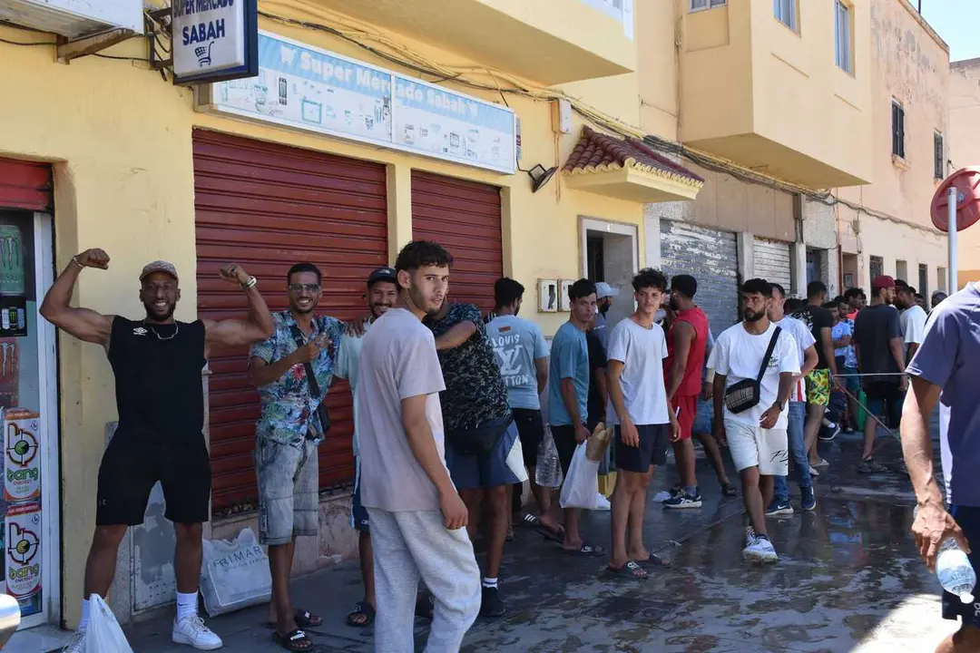 Varias personas hacen cola en un punto de atenci&oacute;n humanitaria, a 5 de agosto de 2026, en Ceuta (Espa&ntilde;a). Varias personas y agentes sociales, se han reunido en sedes y casas donde reparten comida, ropa y otros productos y dejan ducharse a las personas mig