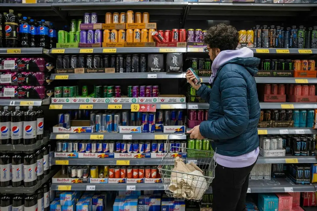 Archivo - Un joven mira la secci&oacute;n de bebidas energ&eacute;ticas en el supermercado.