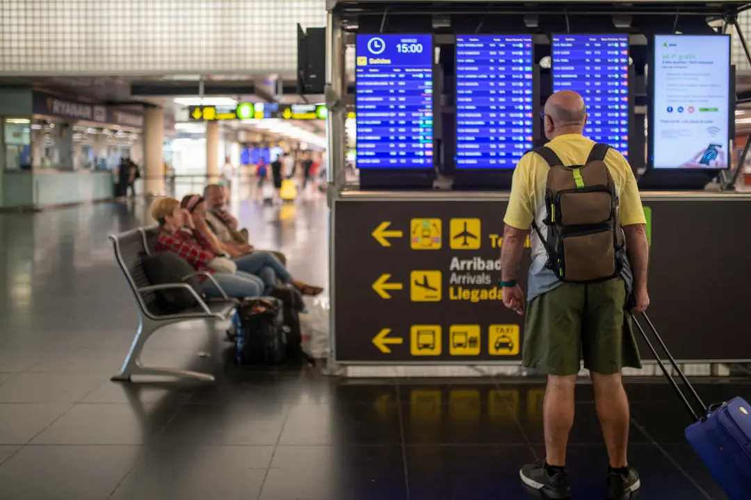 Archivo - Un hombre mira un panel de llegadas y salidas en el Aeropuerto Josep Tarradellas Barcelona-El Prat, en Barcelona, Catalunya (Espa&ntilde;a).  