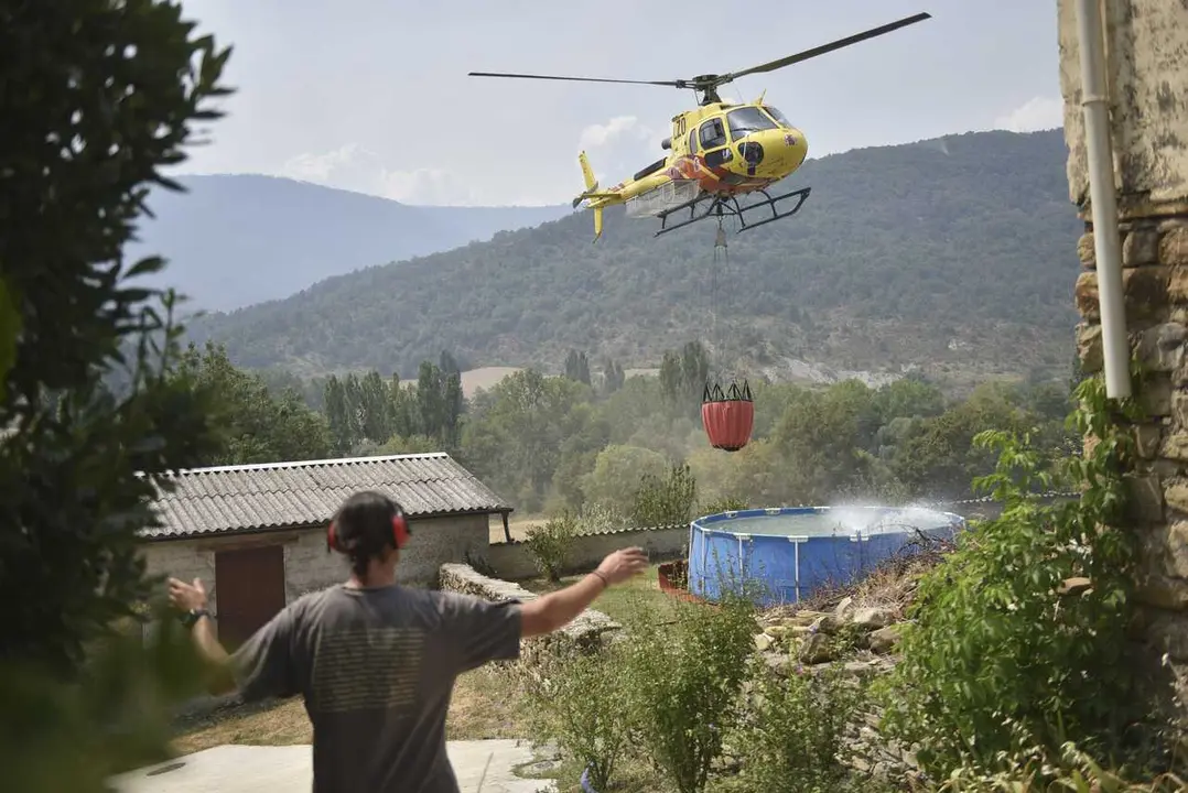 Helic&oacute;ptero recoge agua de una piscina de pl&aacute;stico en Atar&eacute;s  durante las labores de extinci&oacute;n de un incendio forestal, a 16 de agosto de 2026, en Las Pe&ntilde;as de Riglos, Huesca, Arag&oacute;n (Espa&ntilde;a). El operativo desplazado al incendio forestal de Las Pe&ntilde;as de R