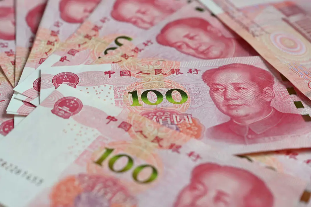 Archivo - FILED - 12 December 2023, China, Beijing: 100 Chinese yuan banknotes lie on a table. Photo: Johannes Neudecker/dpa
