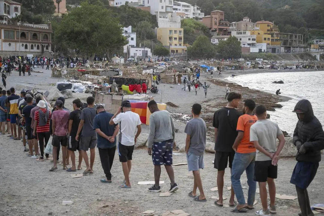Varios inmigrantes en una playa, a 19 de agosto de 2026, en Ceuta (Espa&ntilde;a).