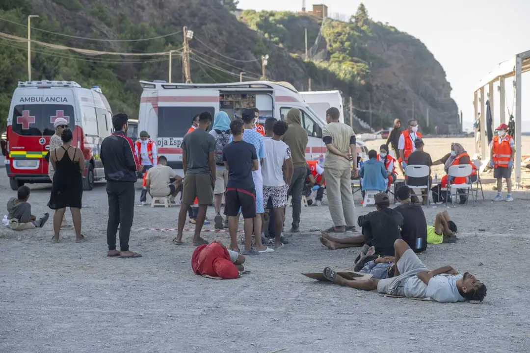 Miembros de la Cruz Roja atienden a los inmigrantes en una playa, a 21 de agosto de 2026, en Ceuta (Espa&ntilde;a). 