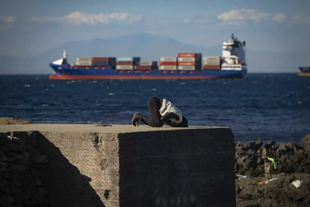 Un inmigrante reza en una playa, a 21 de agosto de 2026, en Ceuta (Espa&ntilde;a)