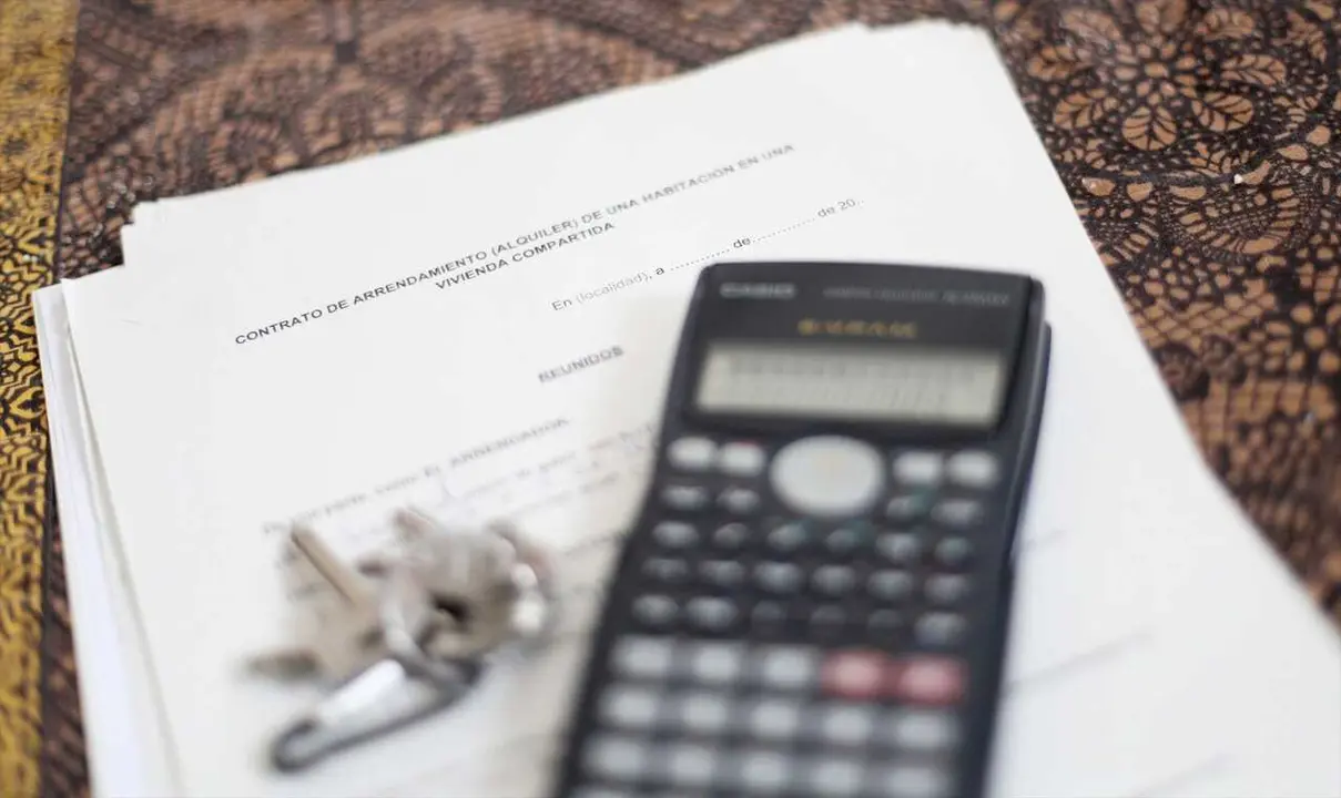 Una calculadora y unas llaves sobre un contrato de alquiler de una habitaci&oacute;n en una vivienda compartida.