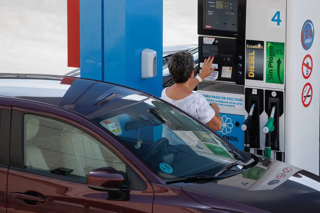 Archivo - Una mujer antes de echar carburante a su veh&iacute;culo en una estaci&oacute;n de servicio