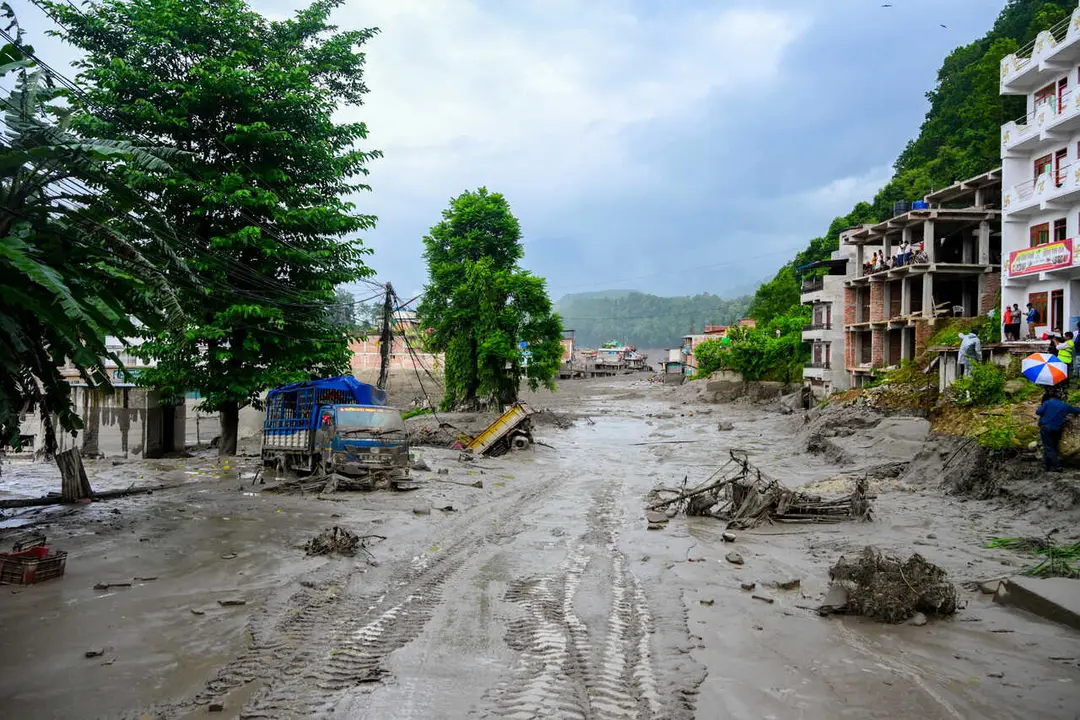 NUWAKOT, NEPAL - AUGUST 26: An aftermath view of flash floods and mudslides along the Trishuli River in Nuwakot, Nepal, on August 26, 2026. A catastrophic flash flood swept through Nepal&rsquo;s northern border region after an ice-and-rock avalanche, reportedly triggered by an earthquake, caused a sudden surge in the Lhende River on the Nepal-China border and sent massive volumes of water, mud and debris downstream into the Bhote Koshi and Trishuli river systems. The disaster devastated settlements in Rasuwa and Nuwakot districts, sweeping away homes, roads, bridges, vehicles and other infrastructure and severely damaging hydropower and power facilities. In Nuwakot, riverside settlements including Trishuli Bazaar, Devighat, Betrawati and surrounding areas suffered extensive destruction, with homes swept away and large quantities of mud and debris deposited across communities. The flood also disrupted communications and transportation routes and prompted authorities to evacuate vulnerable riverside communities and issue warnings along the Bhote Koshi, Trishuli and Narayani rivers. The death toll from the disaster had climbed to 97, while at least 384 tourists and travelers, including foreign nationals, as well as soldiers and police personnel, were reported missing as search-and-rescue operations continued. Nepal Army, Armed Police Force and Nepal Police personnel were deployed to affected areas, while rescue operations were also underway on the Chinese side of the border. Authorities continued to assess the scale of casualties and destruction as access to several affected areas remained difficult because of damaged roads, bridges, heavy sediment and continuing flood risks. The disaster has been described as one of the most severe sudden flood events to strike the Nepal-China border region in recent years.