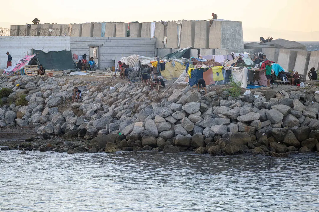Decenas de personas viven y pernoctan en la playa del Trampol&iacute;n, a 28 de agosto de 2026, en Ceuta (Espa&ntilde;a). En la zona de la playa del Trampol&iacute;n permanecen a&uacute;n cientos de migrantes en situaci&oacute;n irregular, donde han vuelto a construir chozas.