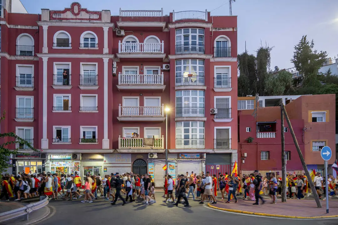 Numerosas personas portan claveles y banderas de Espa&ntilde;a durante una manifestaci&oacute;n ante la Delegaci&oacute;n del Gobierno, a 28 de agosto de 2026, en Ceuta (Espa&ntilde;a). 
