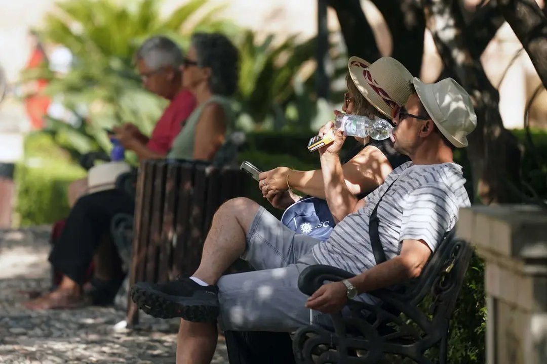 Archivo - Dos personas con ropa veraniega y sombreros. A 18 de julio de 2025, en M&aacute;laga (Andaluc&iacute;a, Espa&ntilde;a).