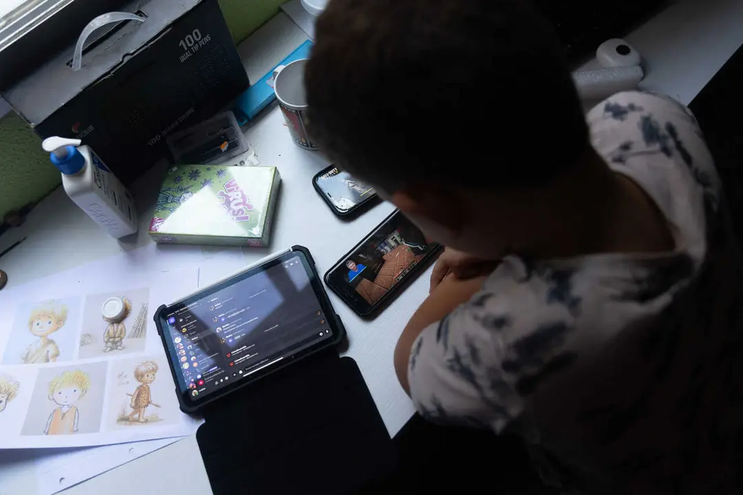 Archivo - Un ni&ntilde;o usa el tel&eacute;fono m&oacute;vil y una tablet, a 18 de octubre de 2023, en Madrid (Espa&ntilde;a). Seg&uacute;n la Vanguardia, en Espa&ntilde;a se estima que el 21% de los adolescentes es adicto a la red y casi la mitad reconoce que tiene 'un contacto activo' cada 15 m