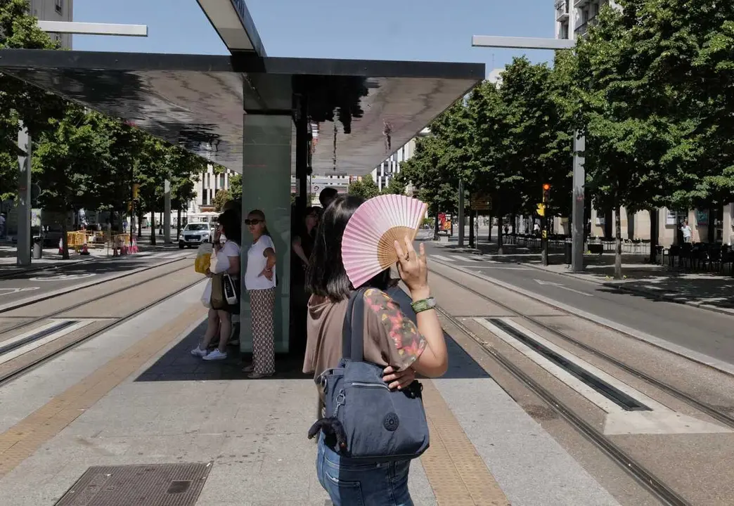 Archivo - Una mujer se tapa del sol con un abanico en la parada del tranv&iacute;a del Paseo de La Independencia, a 10 de julio de 2023, en Zaragoza, Arag&oacute;n (Espa&ntilde;a). 