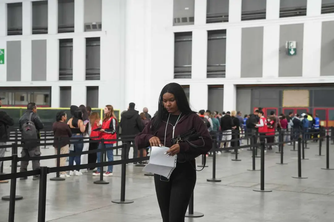 Archivo - Una mujer revisa sus papeles durante el proceso de regularizaci&oacute;n extraordinaria de inmigrantes