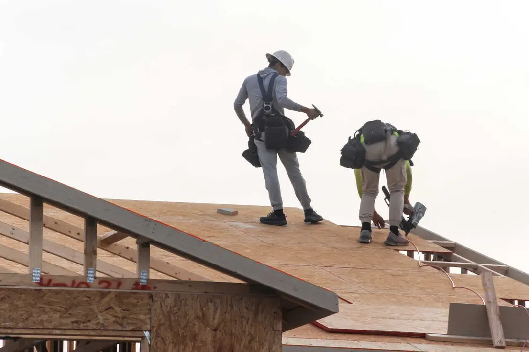 Two construction workers install roof sheathing on a two-story home under construction in the Phoenix metropolitan area. Arizona added the most construction jobs in the U.S. over the past year, gaining 3,900 positions, or 1.7%, according to an analysis of new federal data by the Associated General Contractors of America, which reported construction employment rose in 34 states and the District of Columbia.