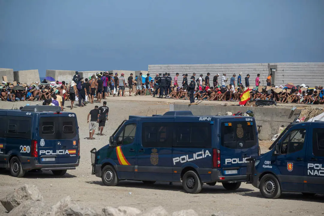 Decenas de migrantes asentados en la playa del Trampol&iacute;n, a 31 de agosto de 2026, en Ceuta (Espa&ntilde;a).
