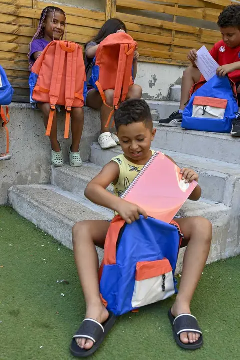 Un ni&ntilde;o usuario del programa CaixaProinfancia con material escolar nuevo