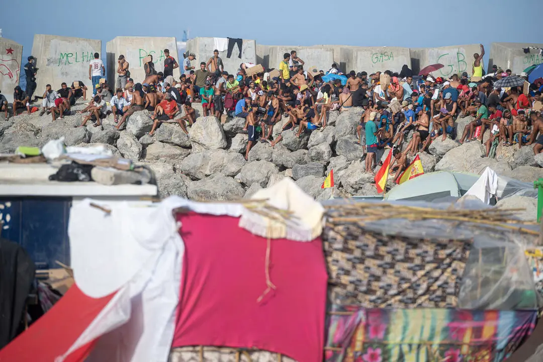 Decenas de migrantes en la playa de El Trampol&iacute;n, a 7 de septiembre de 2026, en Ceuta (Espa&ntilde;a).