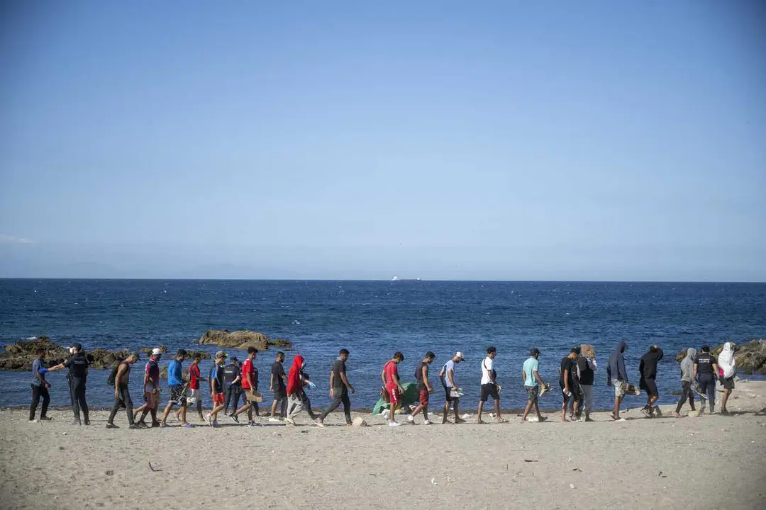 Varios inmigrantes en una playa, a 21 de agosto de 2026, en Ceuta (Espa&ntilde;a).