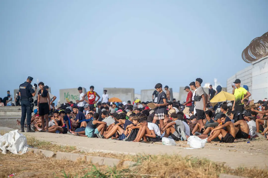 Decenas de migrantes en la playa de El Trampol&iacute;n, a 7 de septiembre de 2026, en Ceuta (Espa&ntilde;a).