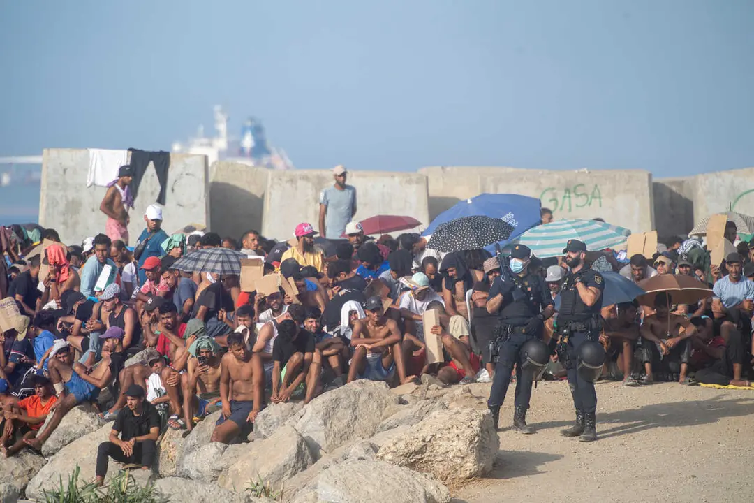 Decenas de migrantes en la playa de El Trampol&iacute;n, a 7 de septiembre de 2026, en Ceuta (Espa&ntilde;a).