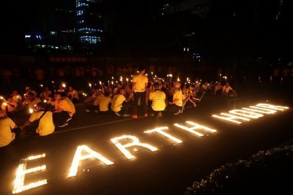 BGS62. Jakarta (Indonesia), 25/03/2017.- Indonesian laborers of the Sudirman Central Business District light candles forming the words 'Earth Hour' in Jakarta, Indonesia, 25 March 2017. Earth Hour takes place worldwide at 8.30 p.m. local time and is a global call to turn off the lights for 60 minutes to raise awareness of the danger of global climatic change. The hour is observed every year on the last Saturday of March. EFE/EPA/BAGUS INDAHONO
