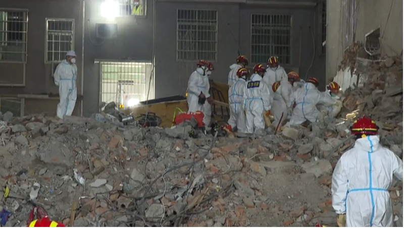 <p> Los servicios de rescate chino buscando supervivientes entre los escombros del edificio </p>