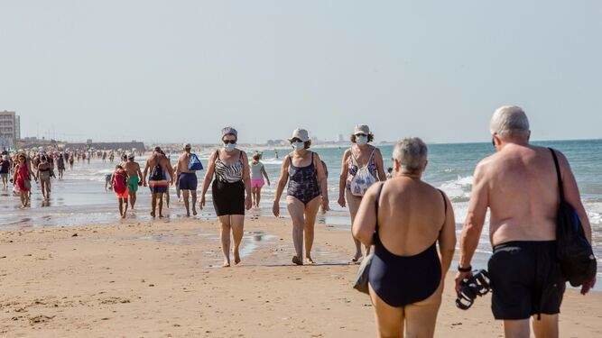 <p> Personas paseando por la playa en Cádiz </p>
