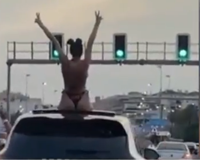 <p> La mujer bailando en bikini sobre el coche </p>