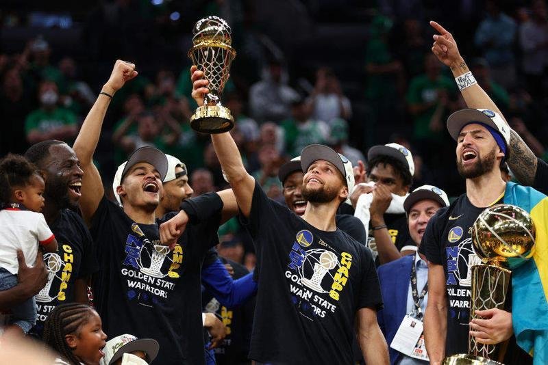 <p> Stepehn Curry levantando el título de MVP de las finales, mientras Klay Thompson sostiene el trofeo de campeones </p>
