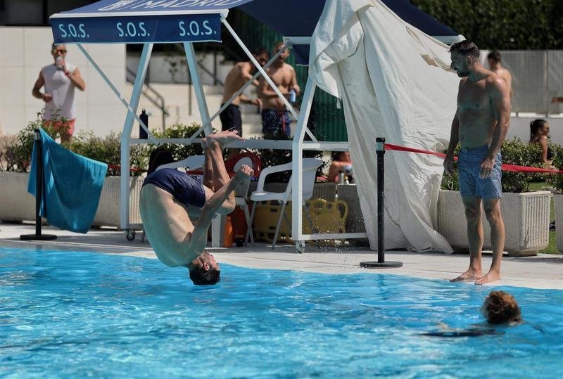 <p> Un hombre salta de voltereta a una piscina en la Casa de Campo, Madrid </p>