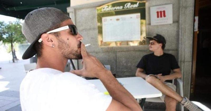 <p> Hombre fumando en una terraza de bar </p>