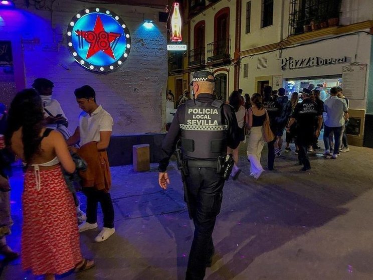  Un policía municipal de Sevilla, le recrimina a un joven que está esperando a la puerta de una discoteca que se coloque la mascarilla 15 de mayo del 2021 en Sevilla, Andalucía - Eduardo Briones - Europa Press 